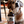 Load image into Gallery viewer, Dog sitting next to a bottle of Crude Carnivore goat bone broth on a wooden floor.
